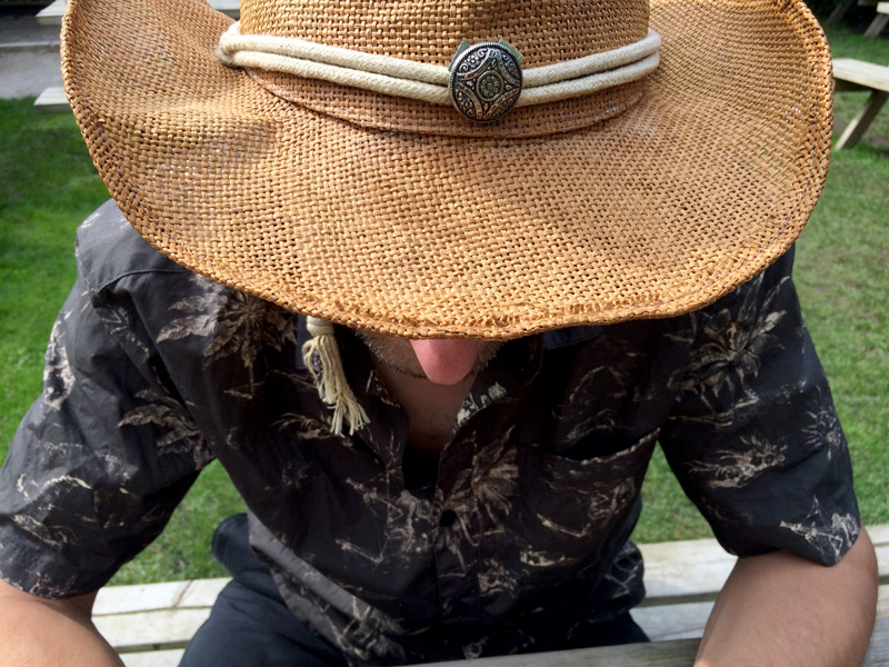 Fletch, face hidden under a straw hat